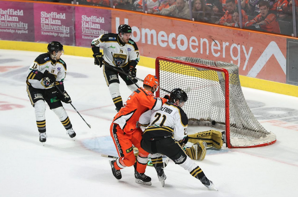 Sheffield Steelers attacking the goal in front of arena branding